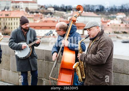 Prag, TSCHECHIEN - 18. MÄRZ 2017: Street-Band-Musiker spielen Cello, Saxofon und Banjo auf der Karlsbrücke im Zentrum von Prag Stockfoto