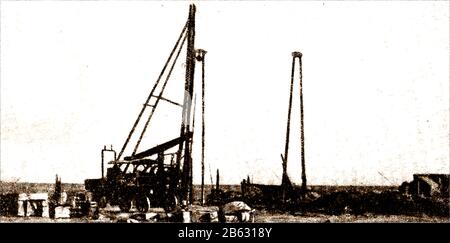 1914 - EIN seltenes Zeitungsfoto, das das Gebäude der Trans-Australian Railway über die Nullarbor-Ebene, Australien, zeigt. Dieses Bild zeigt Arbeiter, die für eine Wasserversorgung langweilig sind. Stockfoto