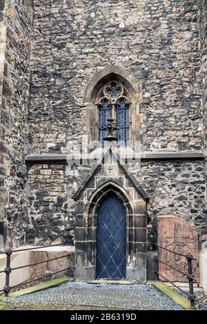 Eine gewölbte Tür zu einer katholischen Kirche oder Kapelle im alten gotischen Stil Stockfoto