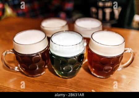 Fünf authentisch gefertigte Becher tschechisches Bier in der Prager Kneipe auf dem Tisch. Verschiedene Biersorten - hell, dunkel und pflanzlich Stockfoto