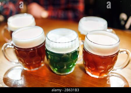 Fünf authentisch gefertigte Becher tschechisches Bier in der Prager Kneipe auf dem Tisch. Verschiedene Biersorten - hell, dunkel und pflanzlich Stockfoto