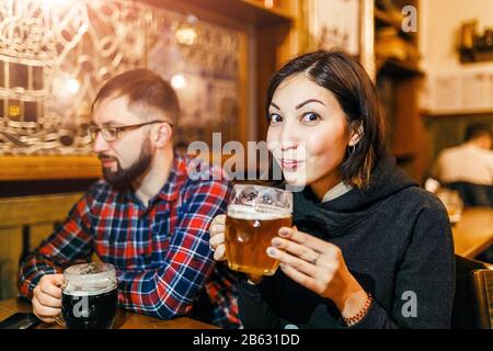 Eine Frau und ihre Freunde probieren in einer Taverne in Prag frisch gebrühtes tschechisches Bier Stockfoto