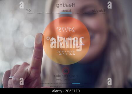 Ansicht Von Hinter Dem Touchscreen, Während Frau Mit App Die Zentralheizung Steuern Kann Stockfoto