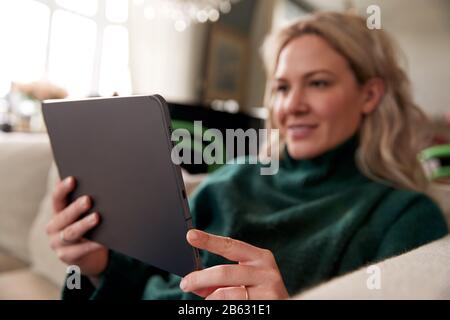 Nahaufnahme Der Frau, Die Sich Auf Dem Sofa Zu Hause Mit Dem Digitalen Tablet Entspannen Kann Stockfoto