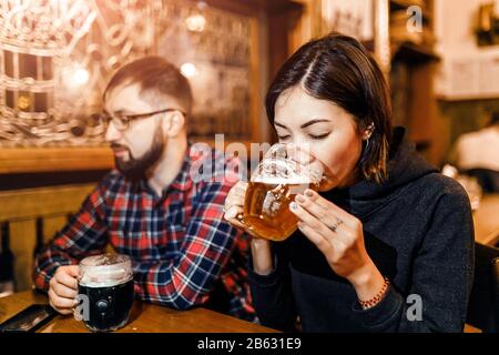 Eine Frau und ihre Freunde probieren in einer Taverne in Prag frisch gebrühtes tschechisches Bier Stockfoto