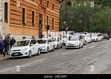 Taxi-Stand Rom, Italien, in der italienischen Hauptstadt. Weiße Taxis parkten gegenüber dem römischen Kolosseum. Stockfoto