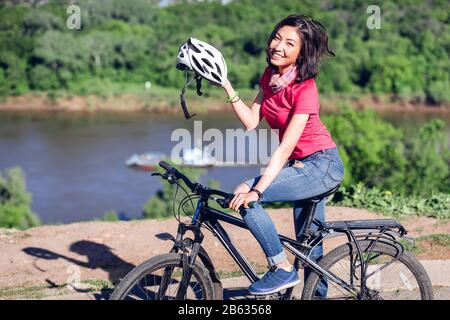 Fahrradhelm - Frau, Radfahren Helm auf außerhalb während der Fahrt mit dem Fahrrad. Stockfoto