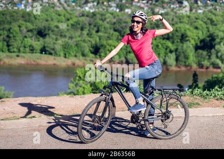 Fahrradhelm - Frau, Radfahren Helm auf außerhalb während der Fahrt mit dem Fahrrad. Stockfoto