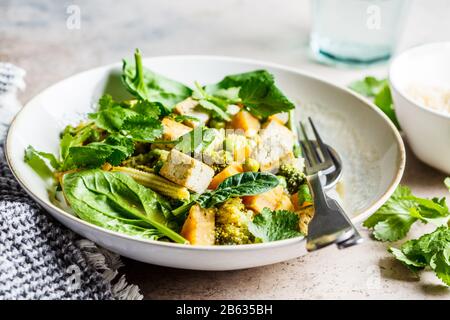 Veganer grüner Curry mit Tofu, Süßkartoffel, Mais und Spinat. Gesundes veganes Lebensmittelkonzept. Stockfoto