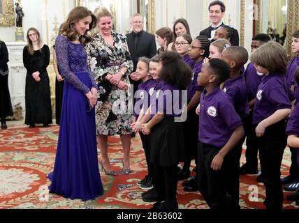 Die Duchess of Cambridge spricht mit einem Schulchor, während sie ein Gala-Dinner im Buckingham Palace, London, veranstaltet, um das 25-Jährige Jubiläum von Place2Be zu feiern. Stockfoto