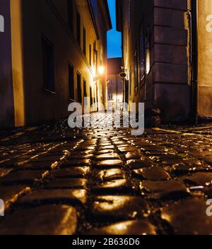 Geheimnisvolle enge Gasse mit Laternen und Straßenpflastersteinen in der Prager Straße in der Nacht Stockfoto