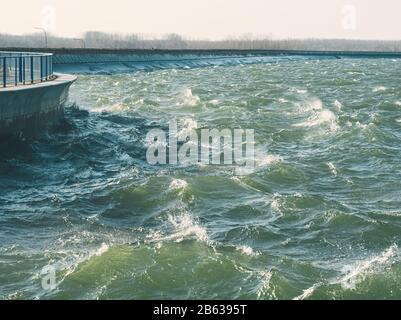 Grünliche Wasseroberfläche mit Stürmischen Wellen im Wasserdamm Stockfoto