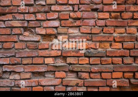 Eine rote Ziegelmauer bricht zusammen. Vintage-Hintergrund. Stockfoto