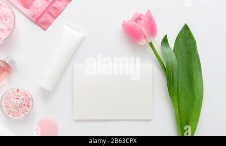 Natürliche kosmetische Produkte aus biologischem Anbau mit rosafarbener Tulpenblume auf weißem Hintergrund. Weiße leere Karte mit Platz für Text. Schönheit, Naturkosmetik für das Bad Stockfoto