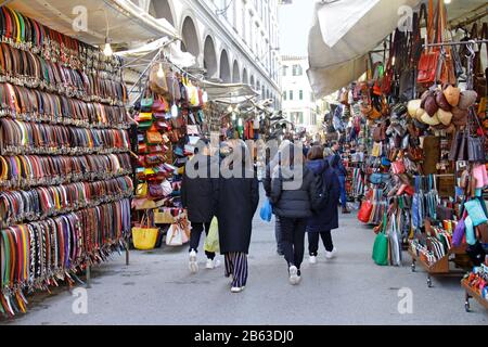 7. Januar 2020 - Florenz, Italien: Touristen gehen an der großen Anzeige von Ledergürteln der Straßenhändler in Florenz, Italien vorbei. Stockfoto