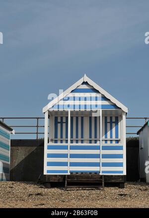 Shoeburyness. Großbritannien. Februar 2020. Eine blau-weiß gestreifte Strandhütte mit blauem Himmel und einem Schindelstrand. Entlang des Strandes bei Shoeburyness. Essex. GROSSBRITANNIEN. 19/02/2020. Credit Garry Bowden/Sport in Pictures/Alamy Stockfoto