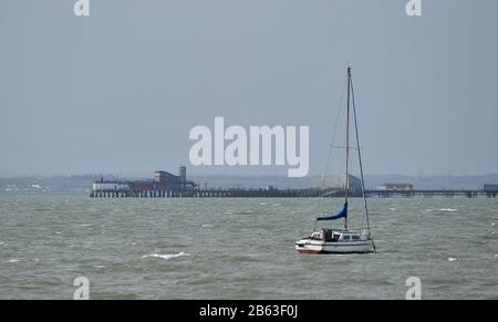 Shoeburyness. Großbritannien. Februar 2020. Ein Segelboot auf dem abgehackten Wasser mit Southend Pier im Hintergrund. Entlang des Strandes bei Shoeburyness. Essex. GROSSBRITANNIEN. 19/02/2020. Credit Garry Bowden/Sport in Pictures/Alamy Stockfoto