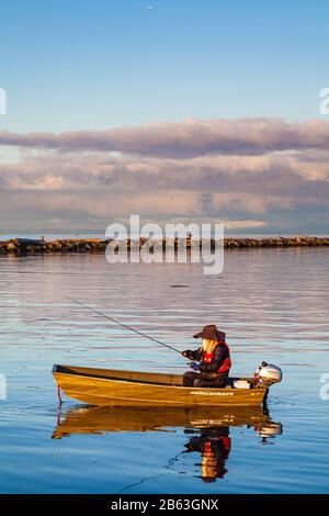 Einsamer Fischer in einem Aluminiumboot bei Sonnenaufgang in Steveston Harbor British Columbia Canada Stockfoto