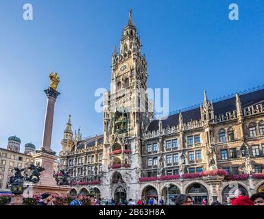 Die reich verzierte Fassade des neuen Münchner Rathauses (Neues Rathaus) mit 85 m hohem Rathausturm und Mariensäule am Marienplatz, München- Stockfoto