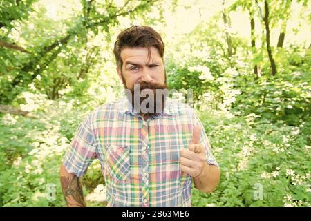 Hey, sieh. Bärtiger Mann Zeigefinger vor ihm auf natürliche Landschaft. Brutale hipster zeigt mit dem Zeigefinger auf Kamera. Caucasain Kerl zeigt auf etwas. So zeigen Geste. Stockfoto