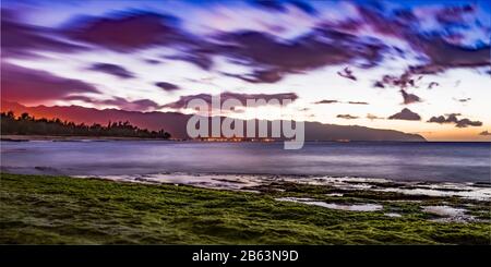 Sonnenuntergang vom Kahawai Beach mit Blick nach Süden über Waimea Point und Laniakea Beach in Richtung Mokuleia und Dillingham Air Field, North Shore, O'ahu, Hawaii Stockfoto