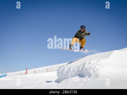 Springende Snowboarder mit blauem und sonnigem Himmel in Zermatt, den schweizer Alpen Stockfoto