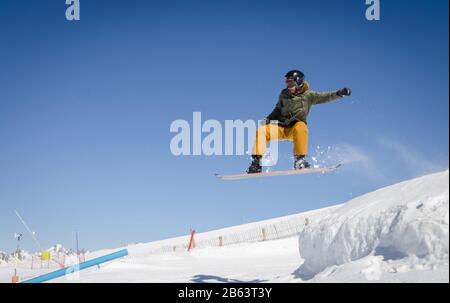 Springende Snowboarder mit blauem und sonnigem Himmel in Zermatt, den schweizer Alpen Stockfoto