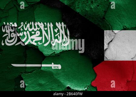 Flaggen Saudi-Arabiens und Kuwaits auf gerissene Wand gemalt Stockfoto