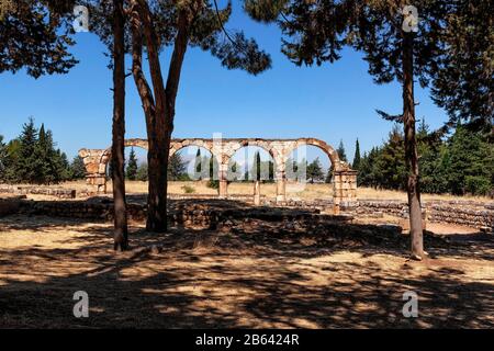 Byzantinische Bögen an der Hauptstraße von Anjar umrahmen die Libanonberge in der Ferne. UNESCO-Weltkulturerbe, Bekaa-Tal, Libanon, Farbe Stockfoto