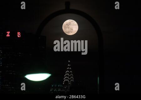 New York, New York, USA. März 2020. Supermoon ist am Montagabend, 09., über Manhattan Island in New York in den Vereinigten Staaten zu sehen. Kredit: William Volcov/ZUMA Wire/Alamy Live News Stockfoto