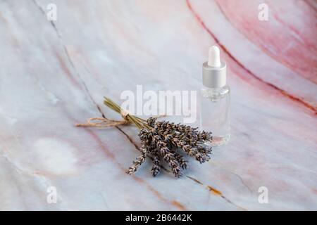 Lavendel entspannendes Mittel. Aroma Wasser und Öl in Flaschen mit Lavendelzweigen.Flaschen auf Marmor Hintergrund. Lavendelöl.Feuchtigkeitsspendende mit Vitaminen Stockfoto