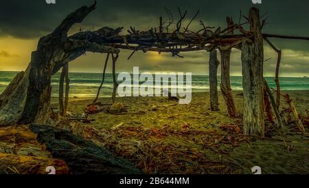 Strandschutz aus Treibholz auf einem launischen dramatischen Sturm Tagholz Stockfoto