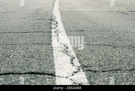 Ein Stück einer alten Fahrbahn mit Fahrbahnmarkierungen Stockfoto