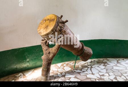 Die originale afrikanische Djembe Trommel mit Lederklinge lag auf einem Laufband, das einen Stamm in Gambia bildet Stockfoto