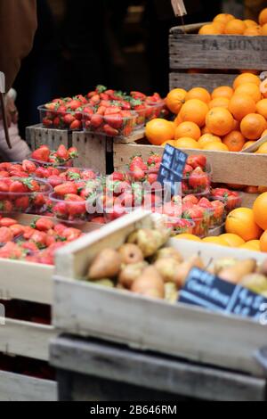 Frische Erdbeeren zum Verkauf auf einem Bauernmarkt in Paris, Frankreich. Frisches Obst in einem Holztray. Stockfoto