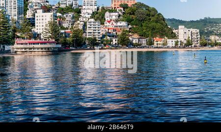 Ein ruhiger Sommermorgen in der Oriental Bay, Wellington, Neuseeland, sieht die Apartmentgebäude und Häuser, die sich im Wasser der Bucht widerspiegeln. Stockfoto