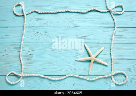 Rahmen aus weißem Seil auf blauem Holzhintergrund. Sommerzeit Urlaub Meer Konzept. Platz für Ihren Text. Stockfoto