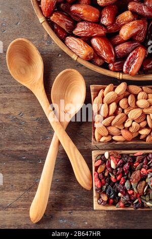 Getrocknete Früchte, verschiedene Nüsse und Samen auf einem alten Holztisch. Draufsicht. Stockfoto