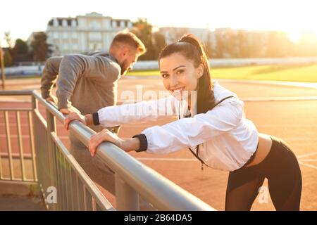 Paar in Sportkleidung dabei warm-up im Stadion Stockfoto