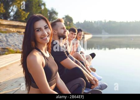 Gruppe von Menschen, die Ruhe im Park entspannen am See Stockfoto