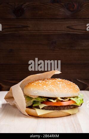 Burger Gesamtansicht von der Seite auf Holzhintergrund. Nahaufnahme. Vertikal. Stockfoto