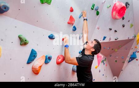 Jungen kaukasischen Mann rock Indoor klettern Stockfoto
