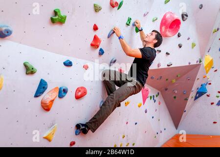 Jungen kaukasischen Mann rock Indoor klettern Stockfoto