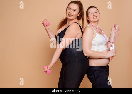 Übergewichtige Frauen auf beigefarbenem Hintergrund mit Kopierbereich Stockfoto