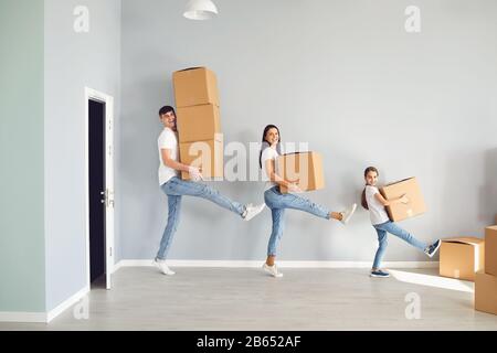 Eine glückliche Familie hat Spaß beim Spielen mit einer Schachtel auf dem Boden in einer neuen Wohnung. Stockfoto