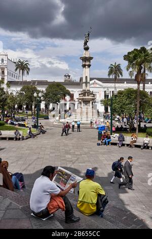 Mann liest Papier auf Stufen in Plaza de la Independencia, Quito, Ecuador Stockfoto