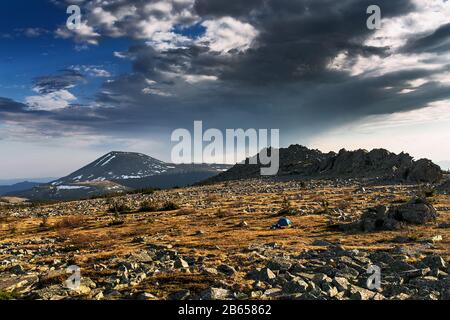 Zelt im Zelt in den Bergen. Frühling, blauer Himmel, Wolken und hohe Gipfel. Stockfoto