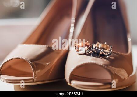 brautschuhe und ungewöhnliche Goldringe Stockfoto