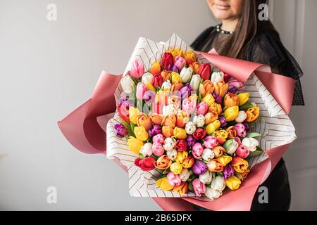 Nahaufnahme Großer Wunderschöner Blumenstrauß aus gemischten Tulpen. Blumenhintergrund und Hintergrundbild. Blumengeschäft Konzept . Wunderschöner, frisch geschnittener Blumenstrauß. Blumen Lieferung Stockfoto