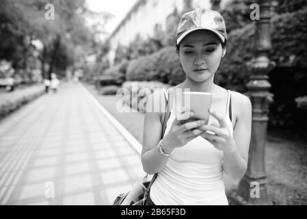 Junge schöne asiatische Touristenfrau mit Telefon in den Straßen der Stadt Stockfoto